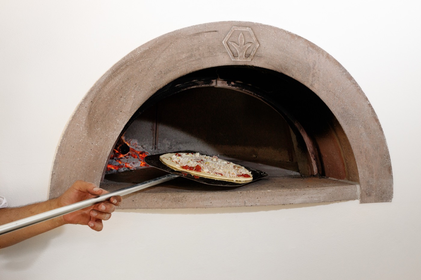 The pizzaiolo working the wood-fired oven